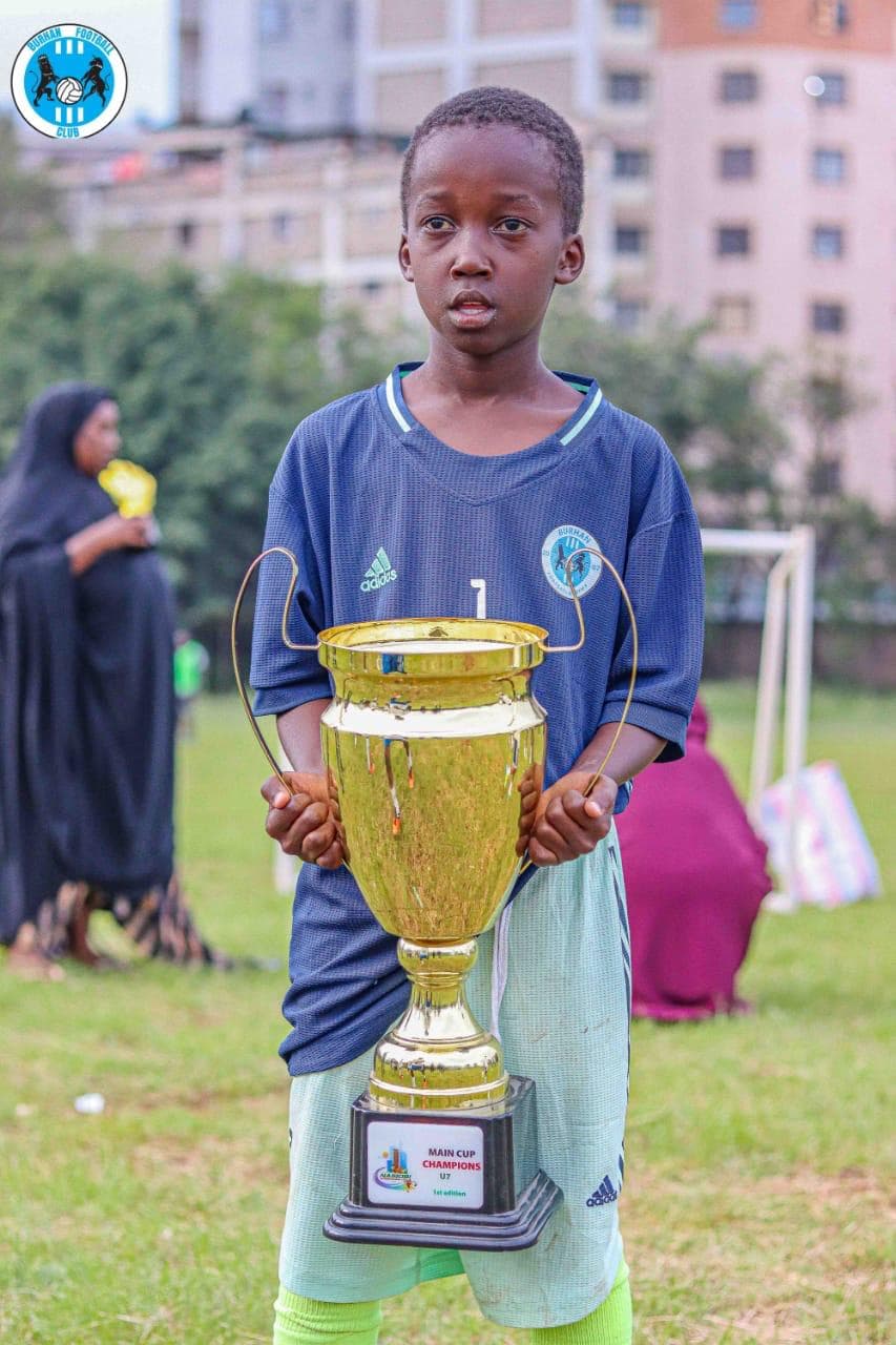 Burhan Academy player proudly presenting the championship cup