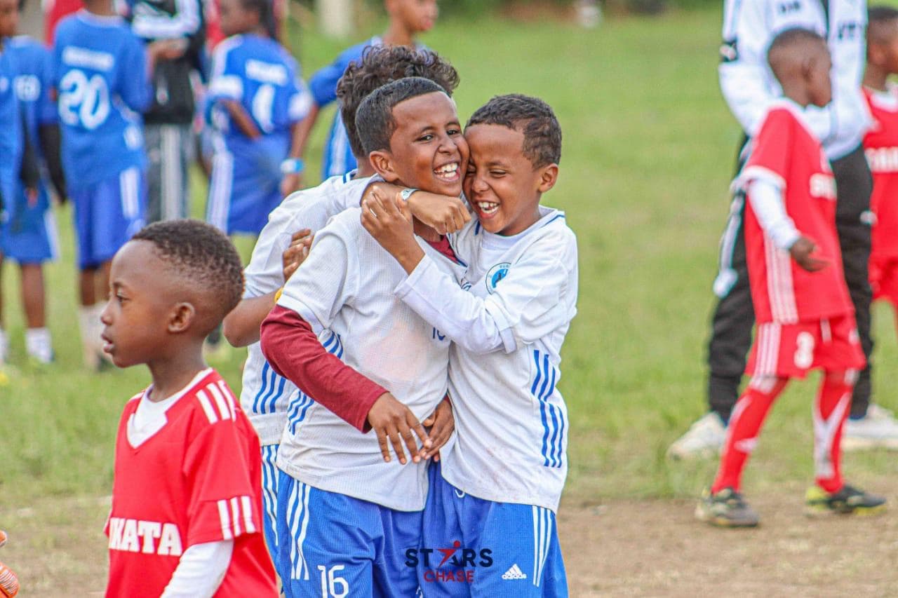 Burhan Football Academy teammates embracing with pure joy on the pitch